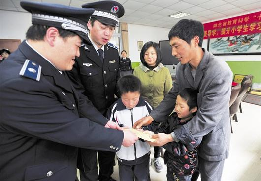 　洪山區(qū)城管隊員將捐款送至徐軍勝（右一）及小安康（右二）手中