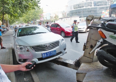 交警將違法停放在緯五路一所學(xué)校門(mén)口的車(chē)輛拖走