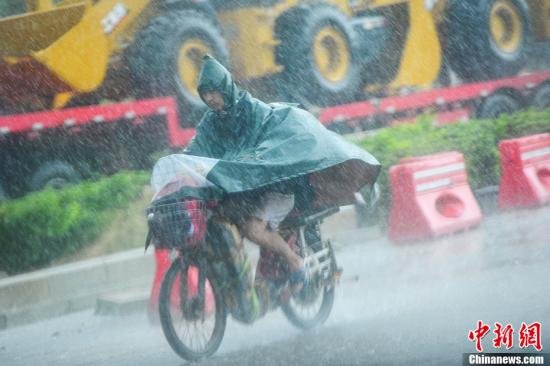 圖為南寧市民冒雨出行。中新社發(fā) 馮抒敏 攝