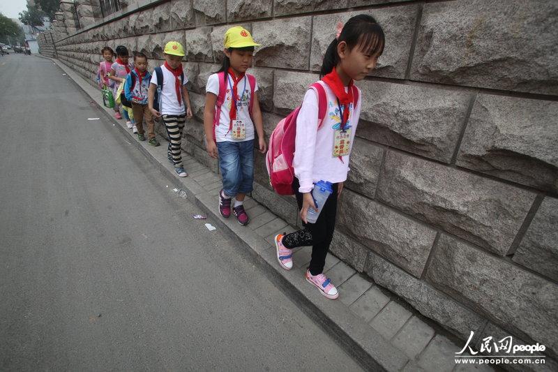 2013年09月11日，濟南運署街上，小學(xué)生走史上“最窄人行道”上學(xué)。圖片來源：CFP