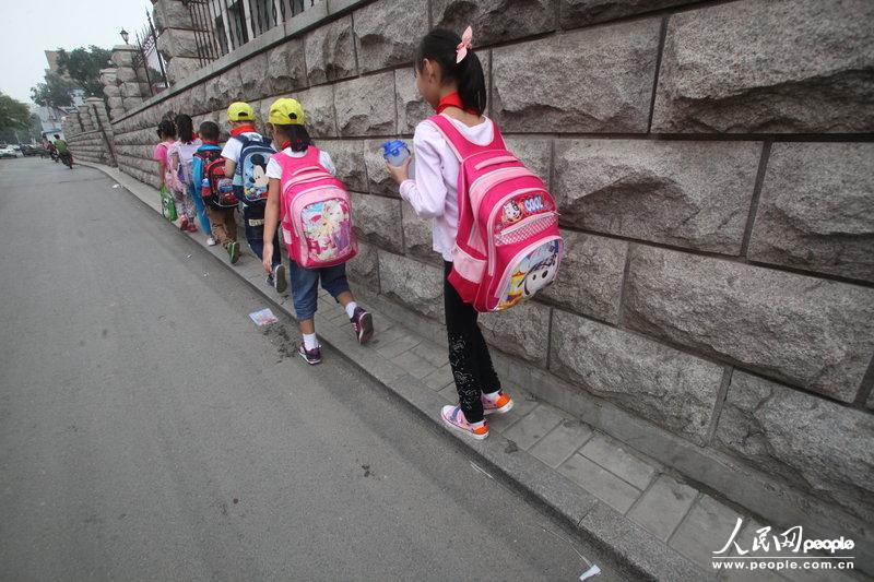 2013年09月11日，濟南運署街上，小學(xué)生走史上“最窄人行道”上學(xué)。