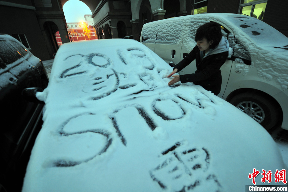 11月18日，行人在車輛的積雪上涂鴉。