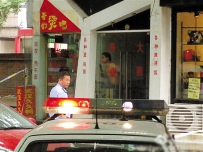 闖入面館的持刀男子與趕來的民警隔著玻璃門對峙，后店內(nèi)一名女童被其劫持。網(wǎng)友供圖