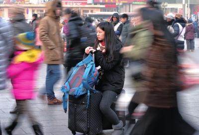 春運(yùn)首日，北京站客流量明顯增多，一名女孩在人流中等待進(jìn)站。