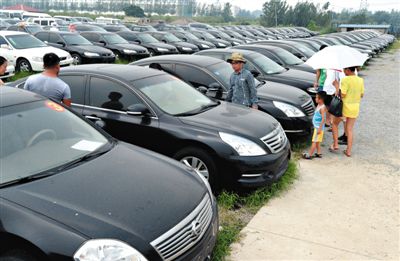 昨日，市民在山東棗莊一家拍賣公司場地上查看待拍賣公車。當日，棗莊市103輛公車公開拍賣。新華社記者