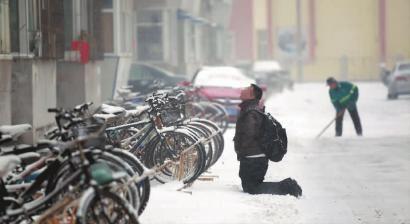 小伙子跪在樓前，一直抬頭看著樓上。 孫立國(guó)/攝