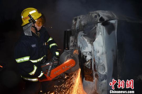 圖為消防人員破拆轎車(chē)，尋找4萬(wàn)元現(xiàn)金。嚴(yán)光濤 攝