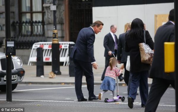 英國(guó)首相卡梅倫步行送女兒上幼兒園。