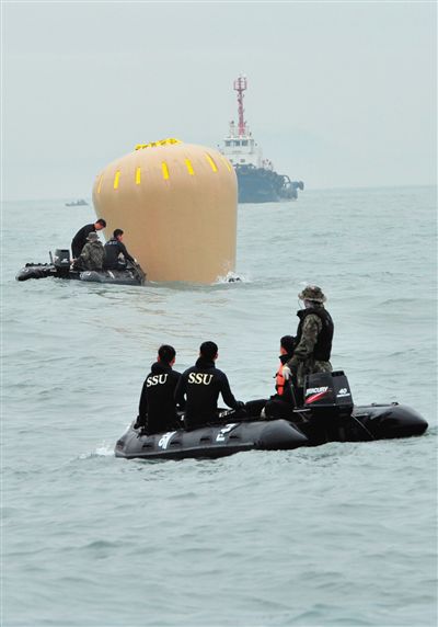 18日，搜救人員準備將氣囊捆綁到沉沒客輪上。