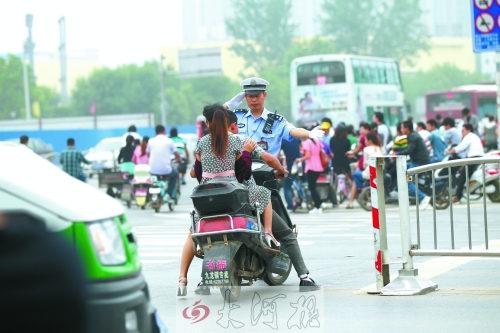 鄭州市交巡警五大隊(duì)民警楊華民正帶領(lǐng)他的同事在路口執(zhí)勤