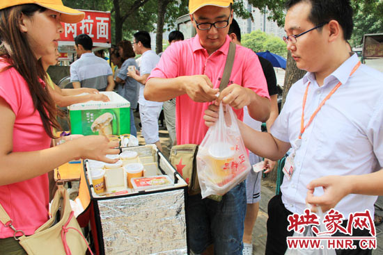 圖為徐貴雨和一名勤工助學(xué)的學(xué)生在街頭義賣快餐。