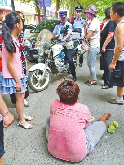 在鄭州優(yōu)勝南路東三街交叉口向東100米處，一名短發(fā)中年女子平躺在路南快車道上，身旁還有一只掉落的拖鞋