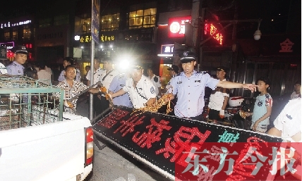 7月8日晚，鄭州市商城路一家占道經(jīng)營的攤販招牌被執(zhí)法隊員“登記保存”