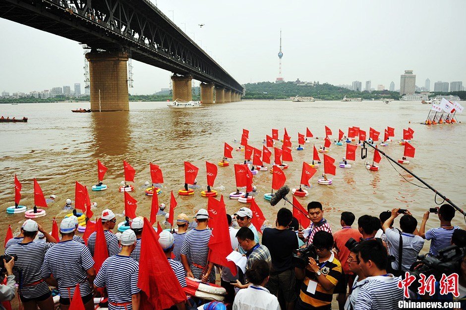 圖為江面上的橫渡方隊(duì)里的選手們劈波斬浪。中新社發(fā) 張暢 攝