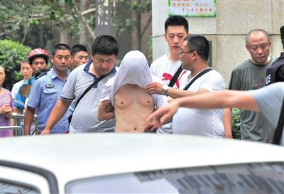 昨日，成都警方抓捕時與毒犯發(fā)生槍戰(zhàn)。一名男犯罪嫌疑人被警方押出。