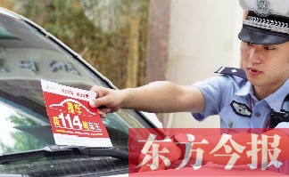 交警將“挪車(chē)請(qǐng)撥打114轉(zhuǎn)車(chē)主”的提示牌放在路邊?？康能?chē)上