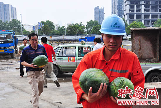 愛(ài)心的哥的姐將買(mǎi)來(lái)的西瓜送給工地上的工人