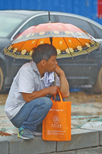 冒雨守在考點門外牽腸掛肚的家長