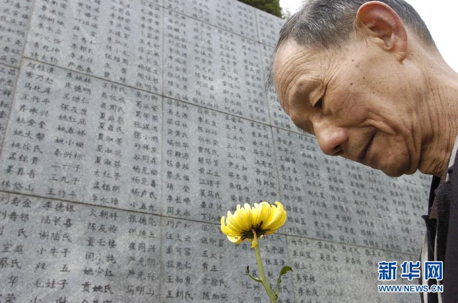 2006年4月5日，74歲的南京大屠殺幸存者佘子清手捧鮮花，祭奠被日軍殺害的母親。