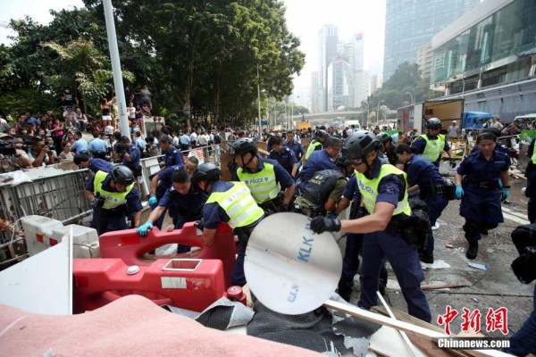 10月14日，警方清除金鐘道障礙物。大批警員在金鐘道現(xiàn)場(chǎng)清拆障礙物。部分警員戴上頭盔將障礙物移走。