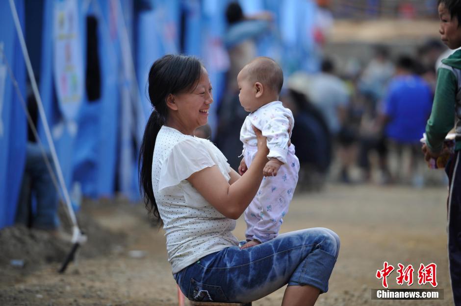 8月6日，一名年輕的母親在和孩子玩樂。