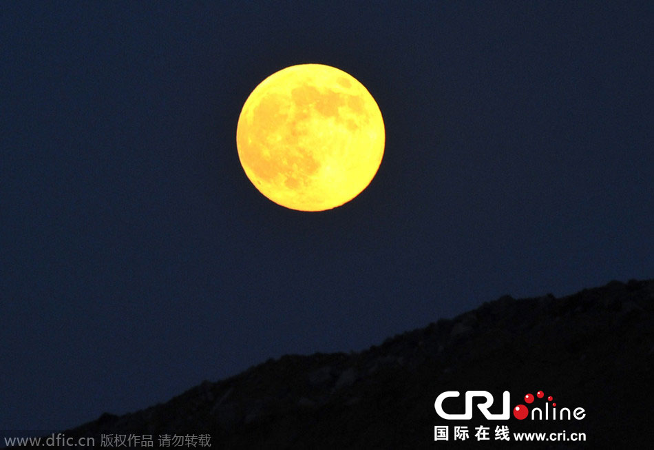 8月10日晚，一輪金燦燦的大月亮在遼寧省大連市東方升起。圖片來源：劉德斌/東方IC