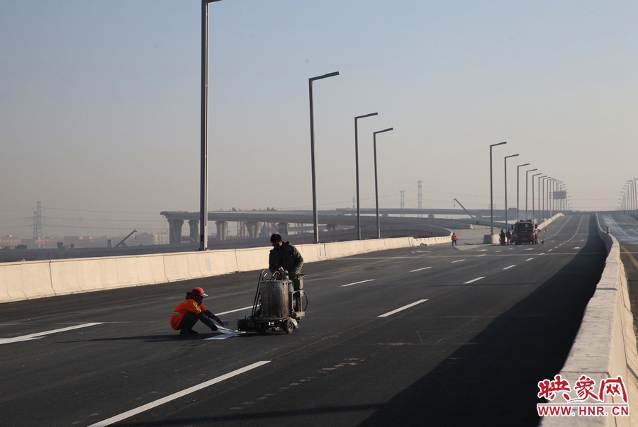 部門路段工人正在噴畫道路標(biāo)線。