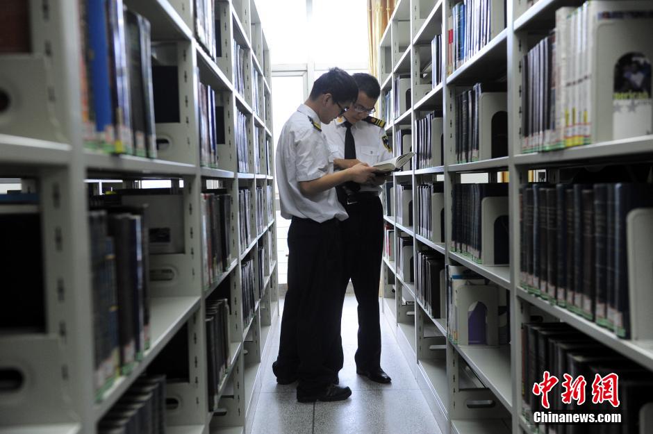 5月8日，武漢輕工大學保安吳濤與江力在圖書館交流學習。中新社發(fā) 張暢 攝