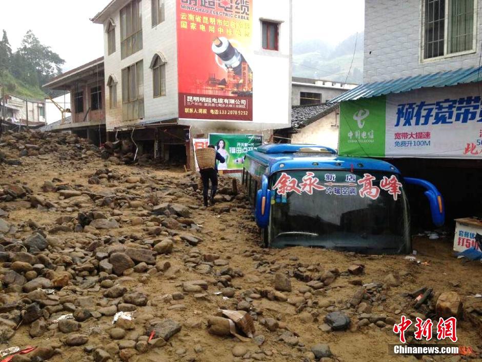 圖為山洪泥石流導沖進鄉(xiāng)鎮(zhèn)街道，導致客車被埋。