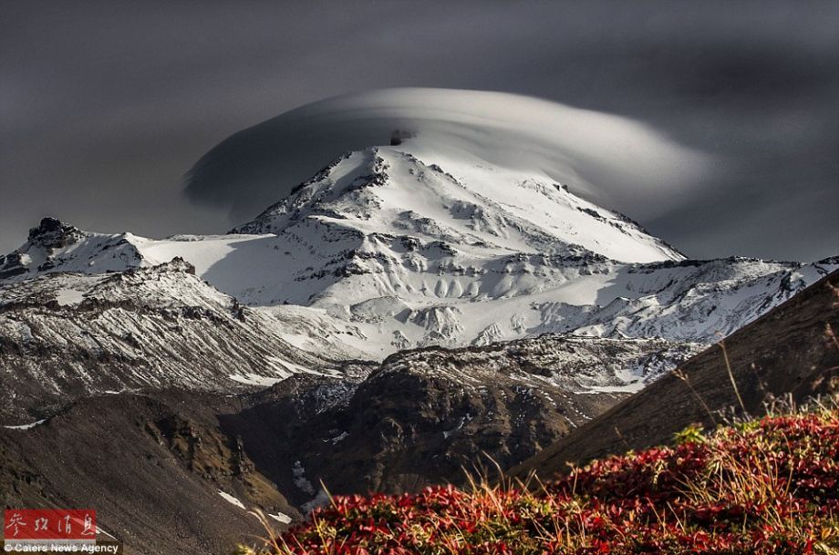 火山上籠罩著類似于外星飛碟形狀的云彩，場景猶如科幻大片。