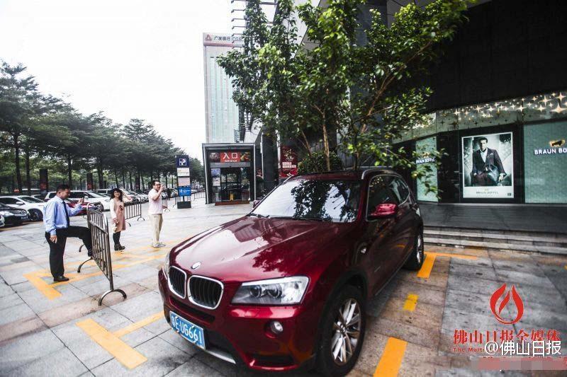 一輛停在停車位上的寶馬轎車，被墜落的樹枝砸中，樹枝徑直插入車內(nèi)，現(xiàn)場(chǎng)引發(fā)不少市民圍觀拍照。