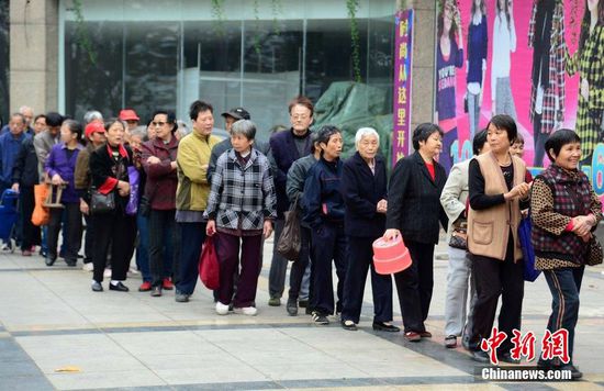 圖為10月28日，在江西九江市一家羊絨皮草服裝服飾博覽會(huì)現(xiàn)場(chǎng)，老人們正在頂著寒風(fēng)排隊(duì)等待領(lǐng)取10元代金劵。