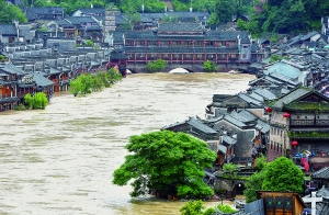 7月16日,沱江兩邊的商鋪和遠(yuǎn)處的虹橋仍淹沒(méi)在洪水中。 新華社發(fā)