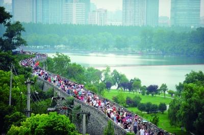 　　昨天,數(shù)萬南京市民參加“環(huán)城七十里”徒步走,圖為解放門城墻上密集的人群。 本版攝影 實習生 王甜