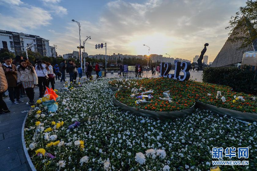 12月14日,觀眾在侵華日軍南京大屠殺遇難同胞紀念館前的“12·13”花壇上擺放鮮花祭奠遇難同胞。新華社記者 沈鵬 攝